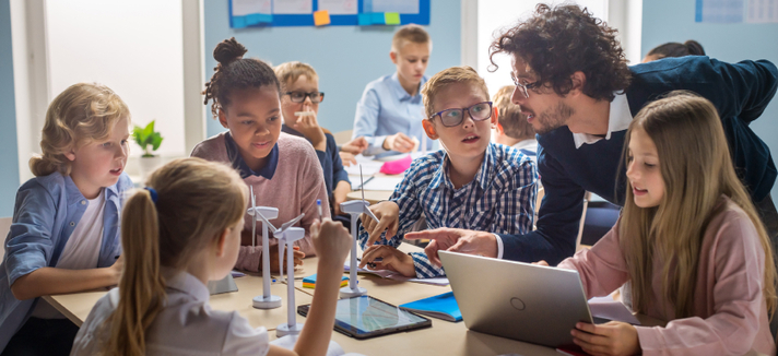 Ein junger Lehrer erklärt einer Schülergruppe etwas © adobe_Gorodenkoff Ein junger Lehrer erklärt einer Schülergruppe etwa