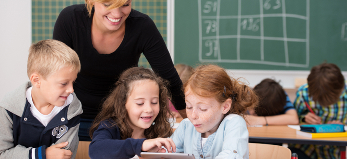 Eine Lehrerin mit Kindern samt Tablet-PC im Unterricht © adobe_contrastwerkstatt  Eine Lehrerin mit Kindern samt Tablet-PC im Unterricht